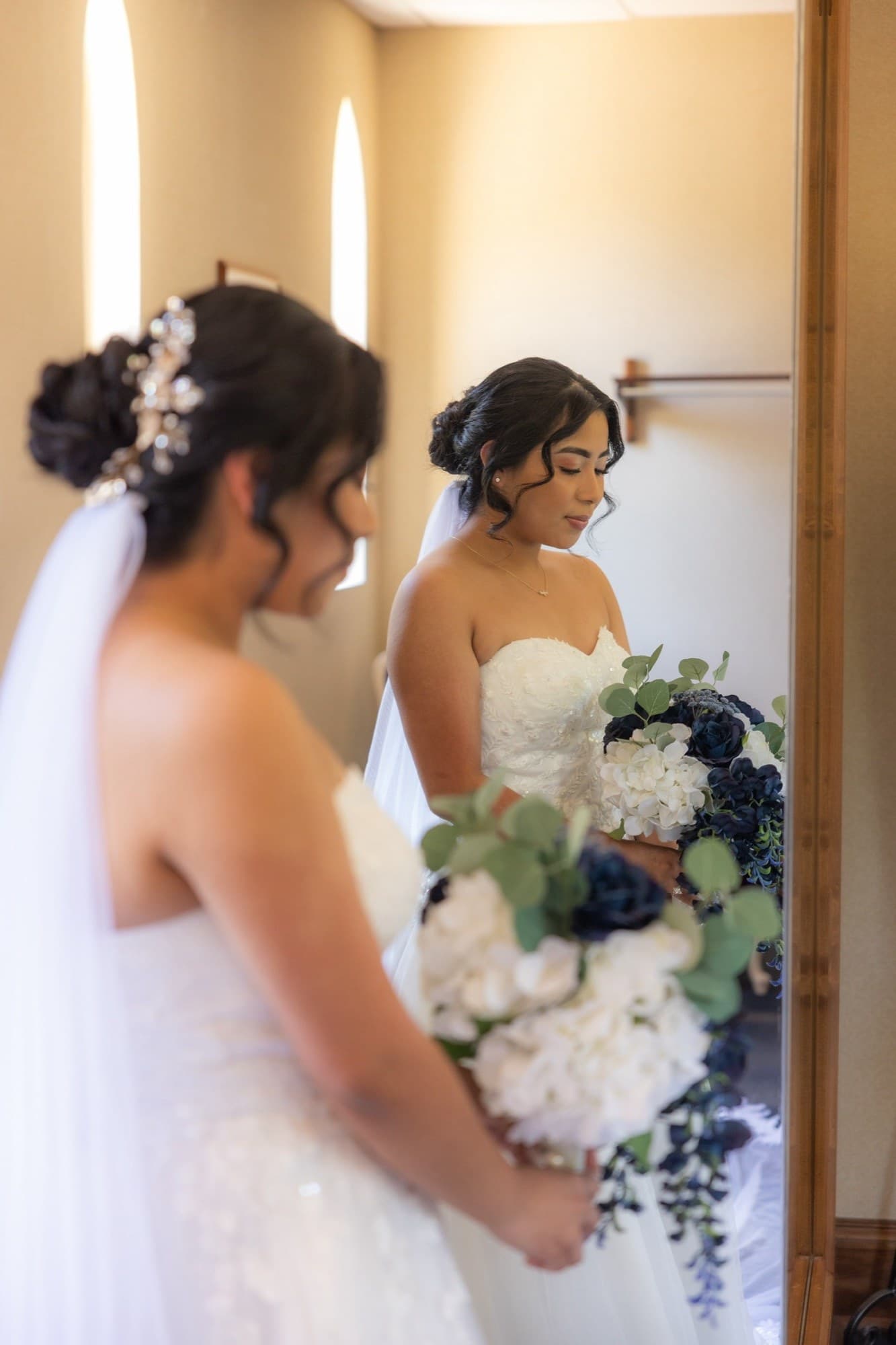 La novia sosteniendo un ramo en cascada de rosas azules y blancas