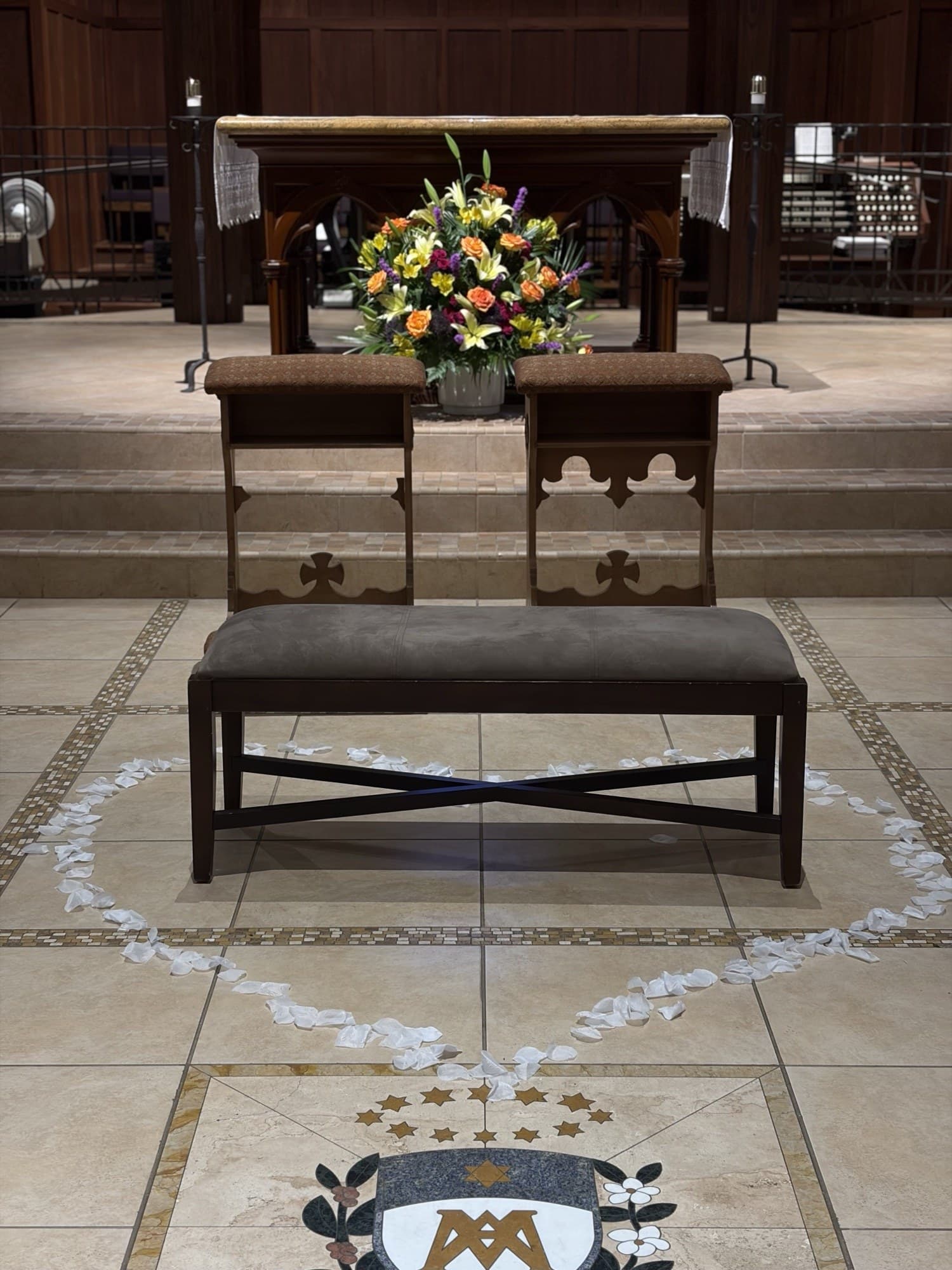 Altar de la iglesia con un arreglo floral colorido y reclinatorio